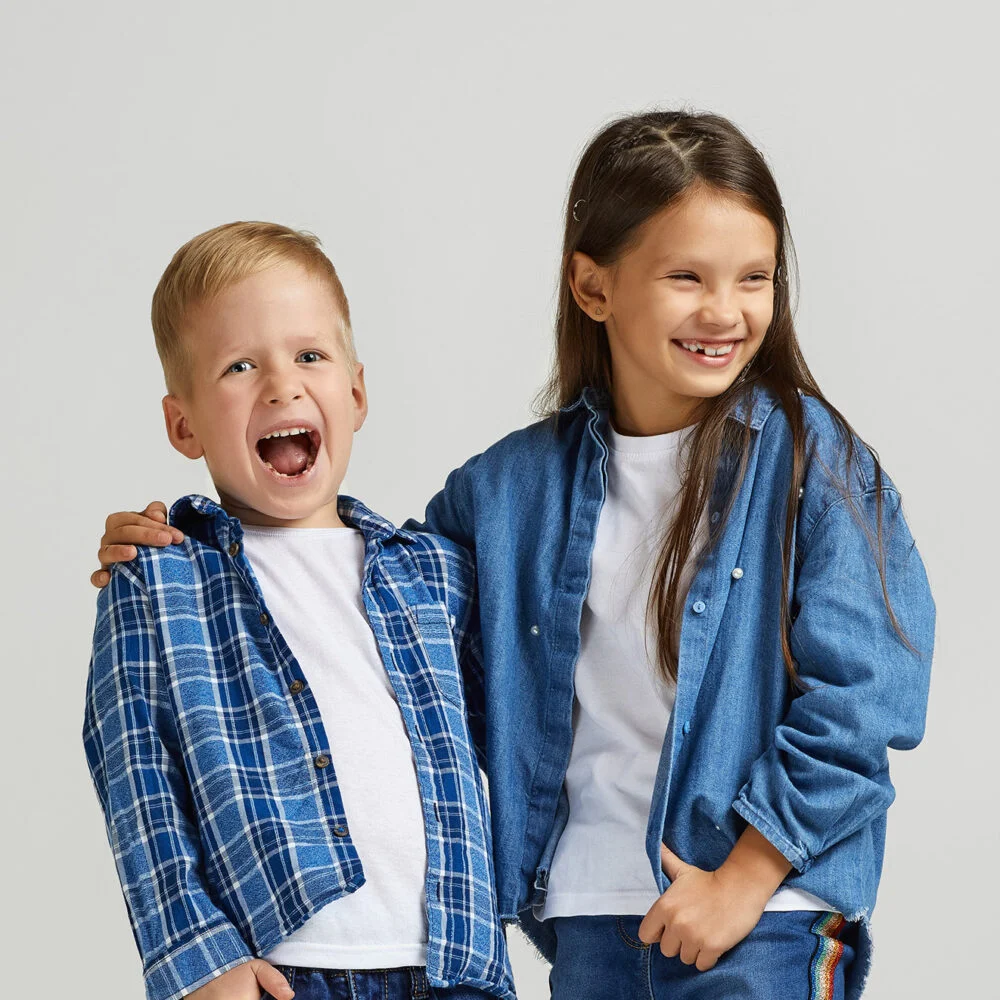 Two children in denim smiling together in kids ministry