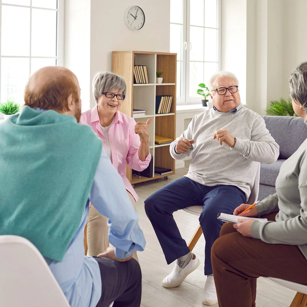 Older adults talking together in a circle of chairs