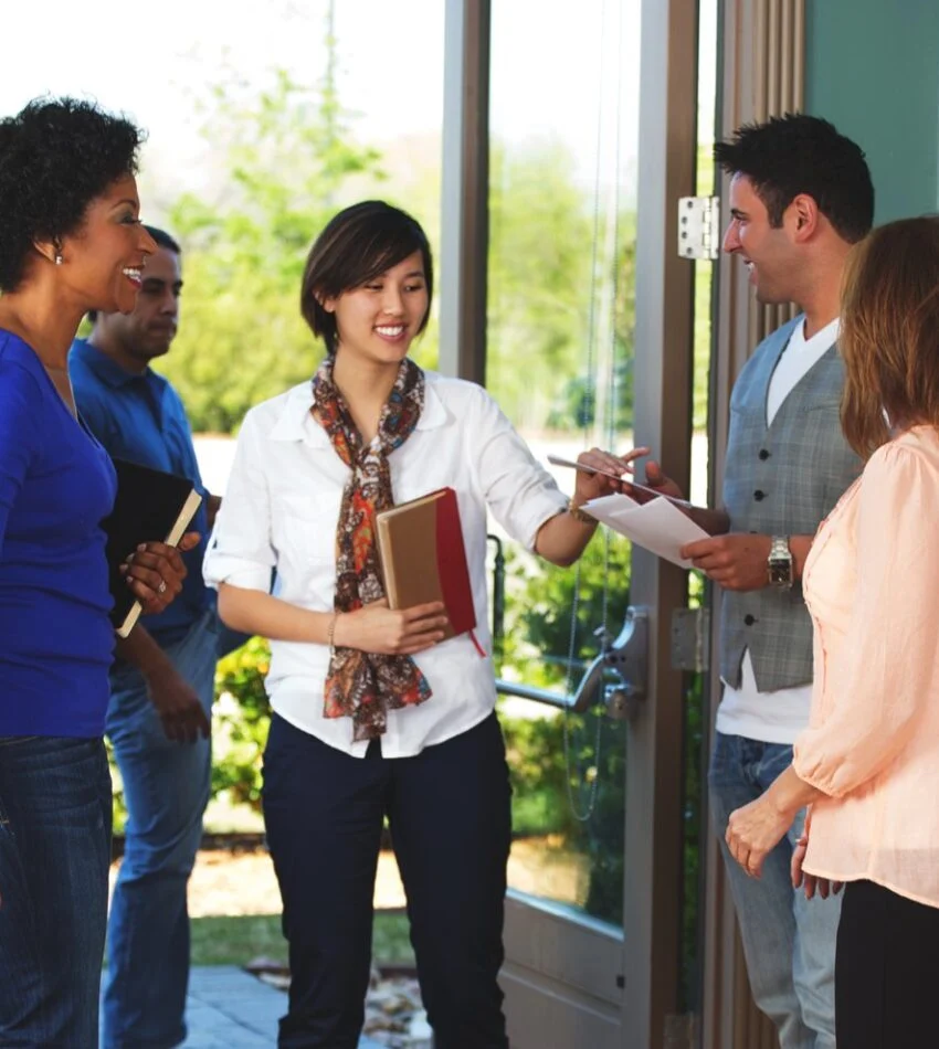 Volunteer greeters welcoming guests at the church doors