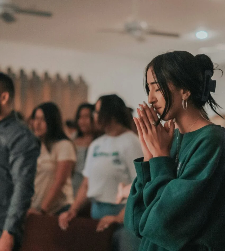 Worshippers singing and praying together during a Sunday service